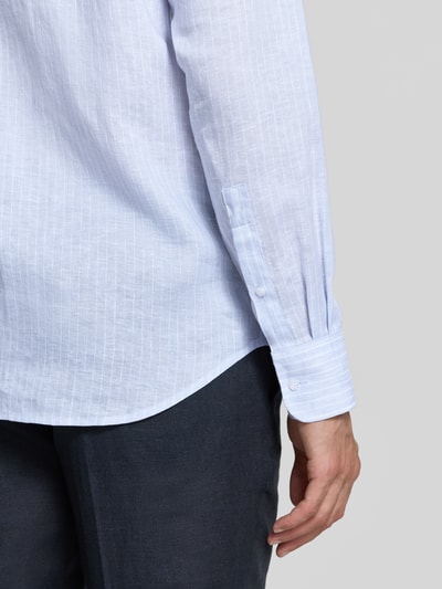 Männermodel trägt Regular Fit Leinenhemd mit Kentkragen von Christian Berg Men in Hellblau, feine Streifen, Sportmanschette, Nahaufnahme Unterarm.