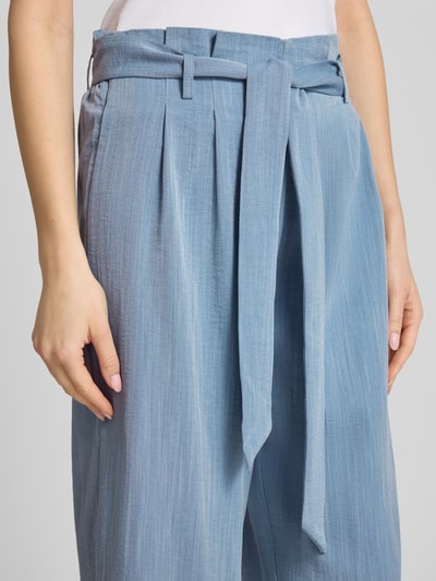Kobiece model nosi Regular Fit Bundfaltenhose aus Viskose-Mix Modell 'MARSA' od Only, efekt: jednolity kolor, krój regular fit, wysoki stan, zakładki w pasie, falbany, szlufki na pasek, wiązany pasek, mieszanka wiskozy, detal: zapięcie na wiązanie, zbliżenie na dolną część tułowia.