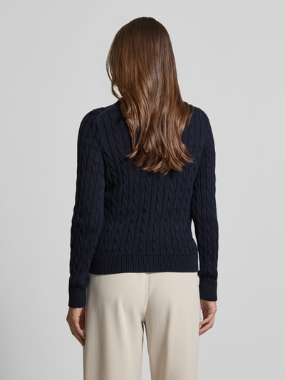 Vrouwenmodel draagt Strickjacke mit Zopfmuster und Rundhalsausschnitt van Jake*s Casual in donkerblauw, pure katoen, slim fit, grof gebreid kabelpatroon, ronde hals, ruglengte maat S 58 cm, mouwlengte S 70 cm, volledige achterkantweergave.