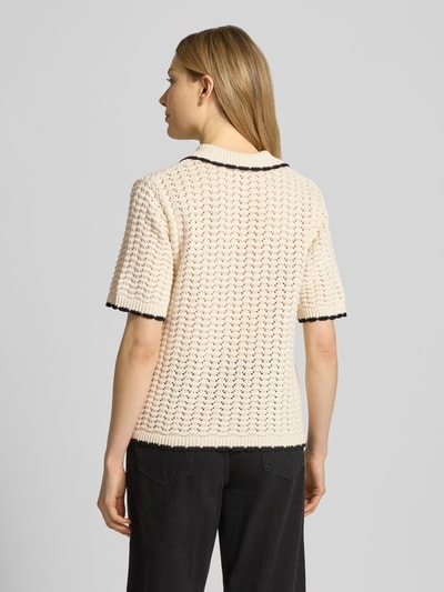 Frauenmodel trägt Regular Fit Cardigan mit Lochmuster Modell 'Muno' von B.Young aus Reiner Baumwolle, Strick-Optik, Kurzärmelig, Umlegekragen, Aufgesetzte Taschen, durchgehende Knopfleiste, Rückenlänge bei Größe S 53 cm, Ärmellänge 25 cm, Creme mit schwarzen Kanten, Strukturstrick, Ganzkörperansicht Rückansicht.