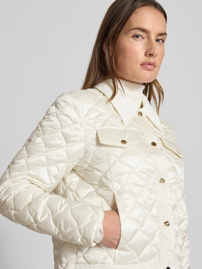 Modelka kobieca nosi Regular Fit Jacke in Stepp-Optik mit Umlegekragen od Marc Cain, kolor kremowy, geometryczna faktura, widok z przodu, zbliżenie na górną część ciała, kieszenie, długość tyłu 53 cm, szerokość ramion 45 cm, szerokość klatki piersiowej 51 cm, długość rękawa 60 cm.