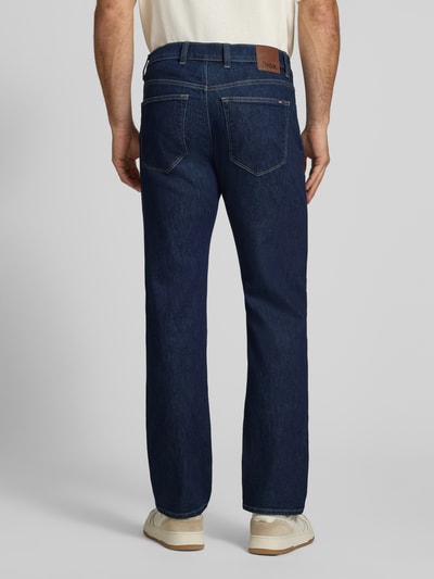 Männermodel trägt Relaxed Fit Jeans aus Baumwoll-Mix Modell 'Clint' von Brax in Dunkelblau mit sichtbaren Nähten, Ganzkörperansicht Rückansicht, Herren Wide & Loose Fit Jeans von Brax.