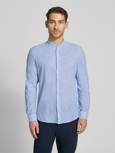 Męski model nosi jasnoniebieską koszulę Slim Fit Freizeithemd aus Leinen-Baumwoll-Mix Modell 'SUN' od CINQUE; len i bawełna, krój slim fit, stójka, długość tyłu w rozmiarze M: 77 cm, szerokość ramion w rozmiarze M: 46 cm, długość rękawa w rozmiarze M: 65 cm; tekstura lekko widoczna, gładkie kolory, widok całej sylwetki z przodu.