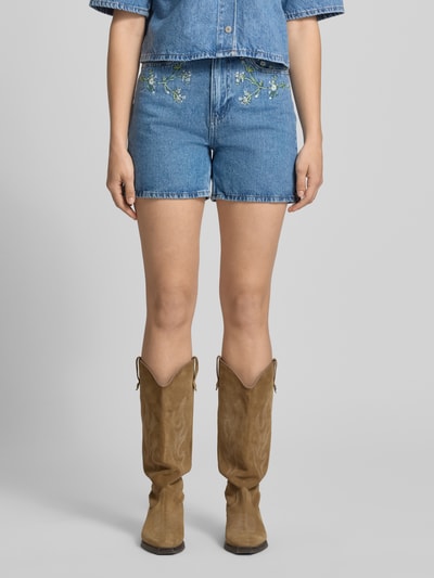 Frauenmodel trägt Regular Fit Jeansshorts aus reiner Baumwolle Modell 'SKY' von Pieces, Denim-Optik, Stickerei, Nieten, 5-Pocket-Design, Ganzkörperansicht von vorne.