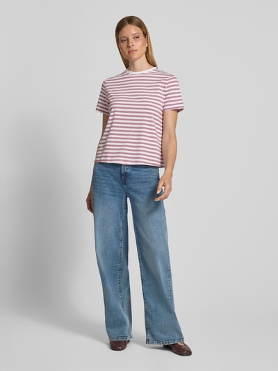 Modelka nosi damski t-shirt z mieszanki bawełny i elastanu VILA, krój regular fit, model 'NORA', okrągły dekolt, długość tyłu w rozmiarze S 57 cm, różowe i białe paski, gładka tekstura, widok całej sylwetki z przodu.