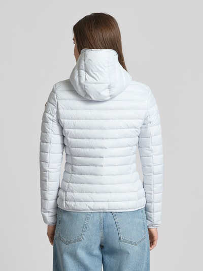 Frauenmodel trägt Slim Fit Steppjacke im Zweiwegereißverschluss Modell 'Daisy' von SAVE THE DUCK, hell, gesteppte Textur, Ganzkörperansicht Rückansicht. Damen Steppjacke mit Kapuze und Reißverschlusstaschen, Rückenlänge 57 cm, Schulterbreite 41 cm, Brustweite 49 cm, Ärmellänge 62 cm.