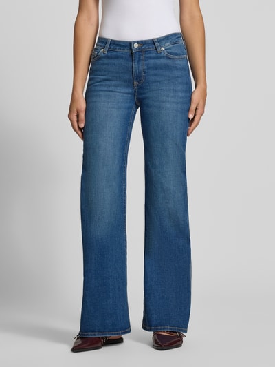 Frauenmodel trägt Flared Jeans mit Knopfverschluss Modell 'ROME' von JJXX in Blau, Baumwoll-Mix mit Stretch, 5-Pocket-Design, Ganzkörperansicht von vorne.