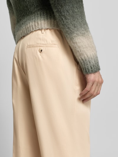 Männermodel draagt Straight Fit Stoffhose mit Viskose-Anteil van MCNEAL in beige, achterzakken, detailopname heup, elastische stof.
