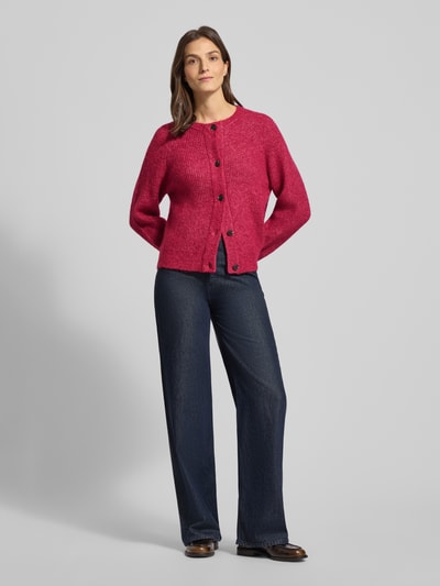 Vrouwenmodel draagt Regular Fit Strickjacke aus Woll-Mix mit Alpaka-Anteil Modell 'LULU' van Selected Femme in effen melange rood, lange raglanmouwen, ronde hals, eenrijige knoopsluiting, gebreide textuur, Ganzkörperansicht von vorne.