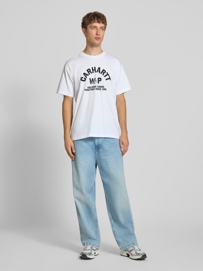 Männermodel trägt Relaxed Fit Jeans aus reiner Baumwolle Modell 'Brandon' von Carhartt Work In Progress in hellem Blau, 5-Pocket-Design, Ganzkörperansicht von vorne, Kontext: Herren Jeans, Knopf- und Reißverschluss, Gürtelschlaufen, Bundweite 46 cm, Innenbeinlänge 73 cm.