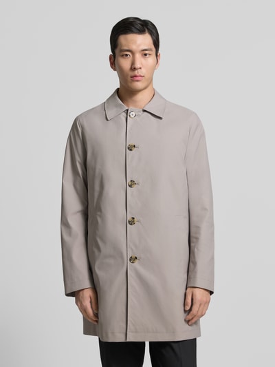 Männermodel trägt Mantel mit Knopfleiste von MCNEAL in Beige, lockerer Schnitt, Kentkragen, Eingrifftaschen, Ganzkörperansicht von vorne