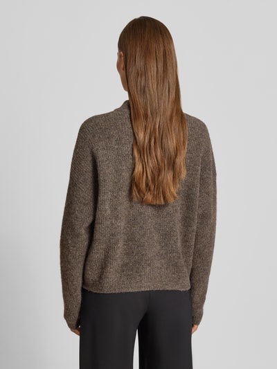 Frauenmodel trägt Regular Fit Cardigan aus Woll-Alpaka-Mix Modell 'Alpha' von Gestuz in brauner Strick-Optik, Ganzkörperansicht Rückansicht. Elastischer Materialmix, Stehkragen, Rückenlänge Größe S: 53 cm, Ärmellänge Größe S: 52 cm.