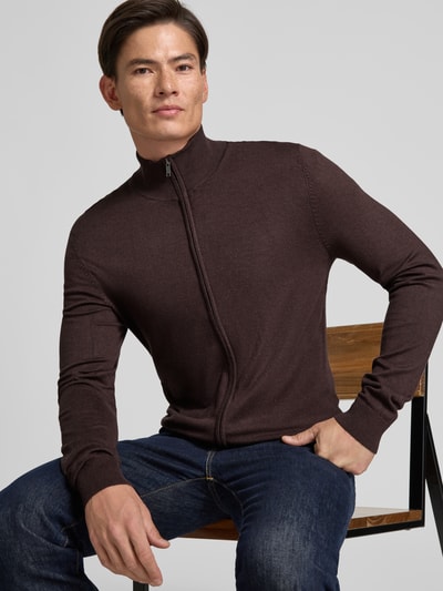 Männermodel trägt Slim Fit Strickjacke aus Viskose-Mix mit Stehkragen von MCNEAL in Dunkelbraun, Reißverschluss, Nahaufnahme Oberkörper.