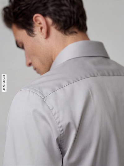 Männermodel trägt Slim Fit Businesshemd aus reiner Baumwolle von Seidensticker in hellgrau, glatte Textur, Ganzkörperansicht Rückansicht. Herren Businesshemd von Seidensticker.