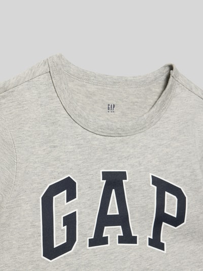 Produktfoto, Regular Fit T-Shirt mit Logo-Print von GAP, dziecięcy t-shirt z bawełny, krój regular fit, nadruk z logo, okrągły dekolt, długość tyłu w rozmiarze 116: 45 cm, jasnoszara melanżowa faktura, duże czarne litery na klatce.