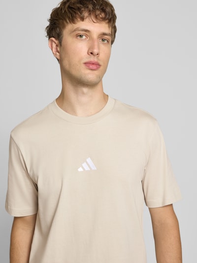 Männermodel trägt Regular Fit T-Shirt aus reiner Baumwolle Modell 'M SL SJ T' von adidas Sportswear in beige, Nahaufnahme Oberkörper