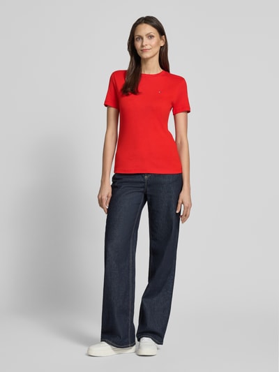 Modelka kobieca nosi Slim Fit T-Shirt aus reiner Baumwolle von Tommy Hilfiger, czerwony, jednolity, krój slim fit, logo, okrągły dekolt, jersey, czysta bawełna, widok całej sylwetki z przodu.