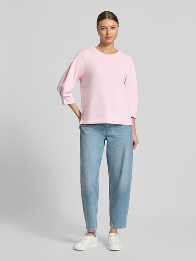 Frauenmodel trägt Comfort Fit Sweatshirt aus Modal-Mix von s.Oliver RED LABEL in zartem Rosa, unifarben, 3/4-Arm, Material mit glatter Textur, Ganzkörperansicht von vorne.