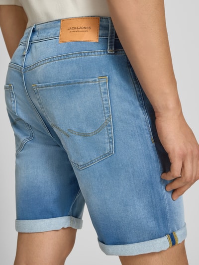 Männermodel trägt Regular Fit Jeansshorts mit Umschlag Modell 'RICK' von Jack & Jones, Used-Look, hellblau, Nahaufnahme Rückansicht. Baumwoll-Mix mit Viskose-Anteil, sichtbare Gesäßtaschen.