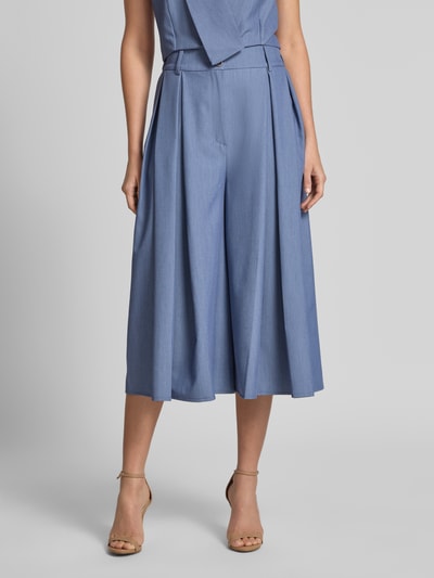 Frauenmodel trägt Culotte mit Biesen und Eingrifftaschen von Rinascimento in hellblau, Material-Mix, lockerer Schnitt, Nahaufnahme Oberkörper.