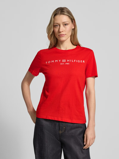 Frauenmodel trägt Regular Fit T-Shirt aus reiner Baumwolle von Tommy Hilfiger, Optik: Unifarben, Logo-Detail, Label-Schriftzug, Rundhals, Kurzarm, Jersey, Ganzkörperansicht von vorne.
