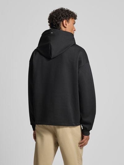 Männermodel trägt Regular Fit Hoodie aus Baumwoll-Mix Modell 'DINEO' von HUGO, Optik: Unifarben, Ganzkörperansicht Rückansicht.