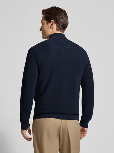 Männermodel trägt Cardigan mit Zweiwege-Reißverschluss und Label-Stitching von Gant aus reiner Baumwolle, Slim-Fit, Dunkelblau, Ganzkörperansicht Rückansicht.