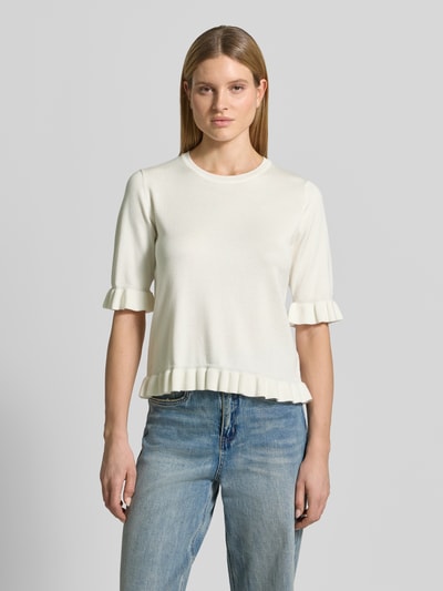 Frauenmodel trägt Regular Fit T-Shirt aus Viskose-Mix Modell 'Katie' von FREE/QUENT in Creme mit Rüschenbesatz, Strick-Optik, Halbarm, Rundhalsausschnitt, Ganzkörperansicht von vorne.