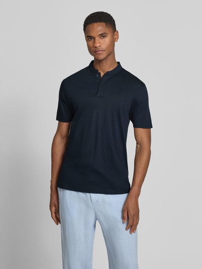 Männermodel trägt Slim Fit Poloshirt mit Stehkragen Modell 'LOUIS' von Drykorn aus Baumwoll-Modal-Mix in Dunkelblau, Ganzkörperansicht von vorne. Rückenlänge bei Größe M: 69 cm.