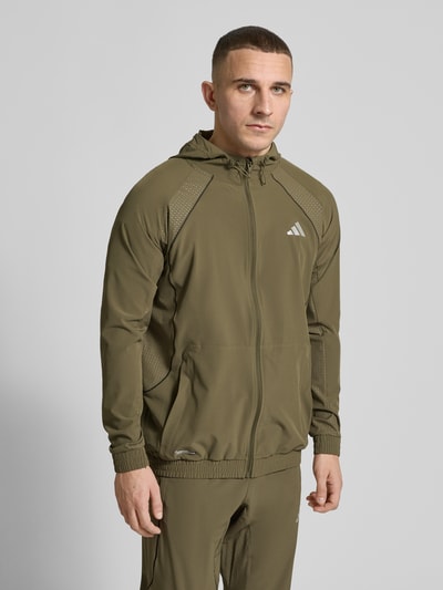 Männermodel trägt Regular Fit Trainingsjacke mit Kapuze von adidas Training in Oliv, Optik: Unifarben, Nahaufnahme Oberkörper