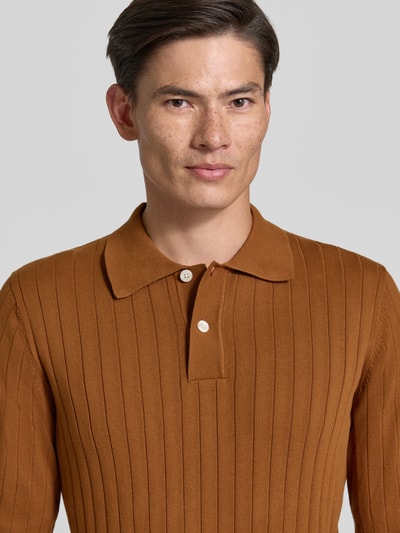 Männermodel trägt Regular Fit Poloshirt aus reiner Baumwolle Modell 'TORINO' von Selected in Braun mit Rippstruktur, Nahaufnahme Oberkörper. Herren Poloshirt von Selected.