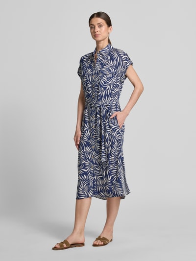 Frauenmodel trägt Hemdblusenkleid aus Viskose mit Brusttaschen von Apricot, gemustert in Blau und Weiß, Taillierter Schnitt, Midikleid, Hemdblusenkragen, Knopfleiste, Ärmel mit Aufschlag, Brusttaschen mit Knopfverschluss, Bindegürtel, Rückenlänge 118 cm, Brustweite 49 cm, Ärmellänge 5 cm, Ganzkörperansicht von vorne.