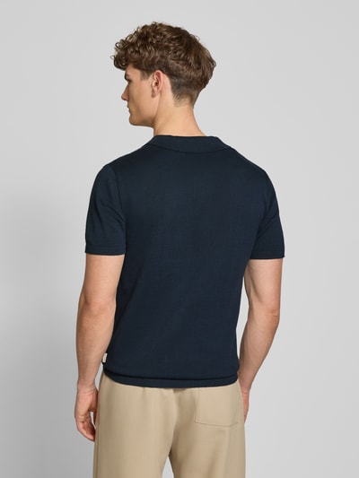 Männermodel trägt Regular Fit Poloshirt in Strick-Optik Modell 'Bray' von Blend, Reine Baumwolle, Kurzärmelig, Rückenlänge 68 cm, Ganzkörperansicht Rückansicht.