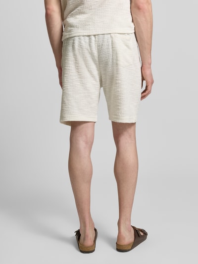 Männermodel trägt Shorts mit elastischem Bund von MCNEAL in Creme mit Strukturmuster, Material-Mix mit Baumwoll-Anteil, Regular-Fit, Ganzkörperansicht Rückansicht.
