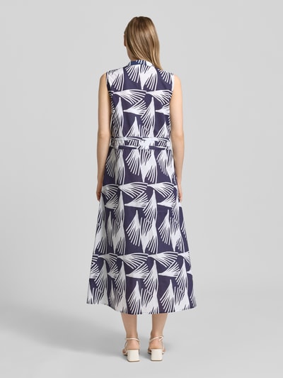 Frauenmodel trägt Hemdblusenkleid mit V-Ausschnitt und Bindegürtel Modell 'Lani' von GUIDO MARIA KRETSCHMER WOMAN aus Reine Baumwolle in A-Linie, Allover-Look mit Knopfleiste als Midikleid, Rückenlänge bei Größe 36: 128 cm, Brustweite: 48 cm, marineweißes Muster, glatte Textur, Ganzkörperansicht Rückansicht.