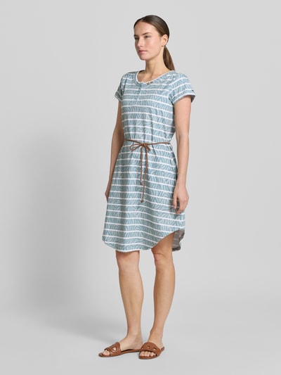 Frauenmodel trägt Knielanges T-Shirt-Kleid mit Bindegürtel von G.I.G.A. DX aus Reine Baumwolle, Gerader-Schnitt, Rundhalsausschnitt, Knopfleiste, Streifenmuster, Ganzkörperansicht von vorne.
