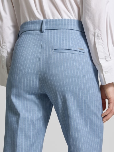Frauenmodel trägt Hose mit französischen Eingrifftaschen Modell 'MAINE' von Brax im Material-Mix mit Baumwoll-Anteil, Gesäßtasche, Straight Leg Fit, hellblau-weiß gestreift, Knopf- und Reißverschluss, Stoffstruktur glatt, Nahaufnahme Rückansicht.