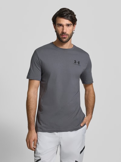 Męski model nosi Regular Fit T-Shirt mit Logo-Print Modell 'Left' von Under Armour, mieszanka bawełny, okrągły dekolt, długość tyłu 72 cm, krój regular fit, widok na całą sylwetkę z przodu