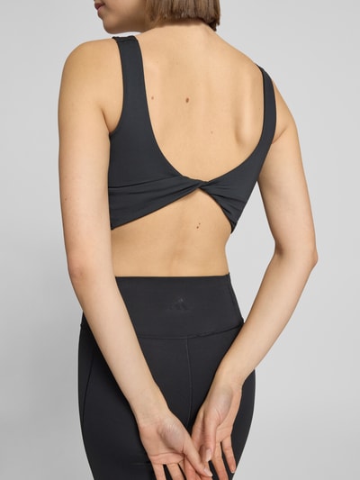 Kobiece modelka nosi Crop Top mit Label-Print od adidas Sportswear, czarny, materiał ze stretchem, krój slim fit, widok całej sylwetki z tyłu.