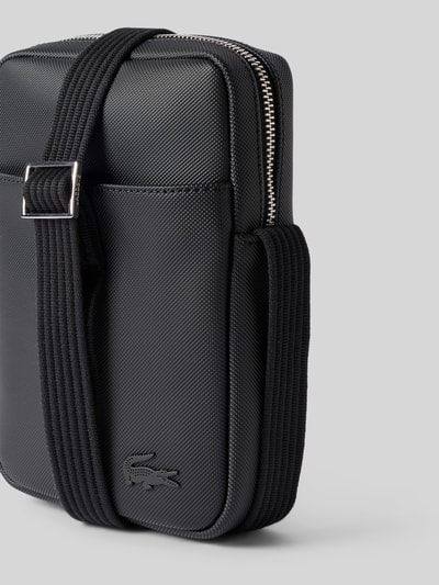 Produktfoto, schwarze Umhängetasche mit Logo-Print 'Classic Vertical Camera B' von Lacoste mit grober Textur und silbernem Reißverschluss, Herren