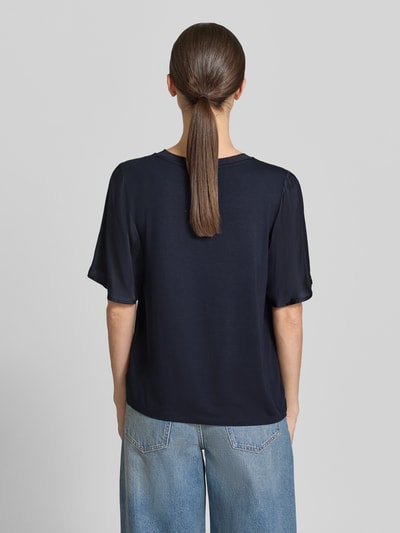 Frauenmodel trägt T-Shirt aus Viskose-Mix mit Rundhalsausschnitt von Comma, Damen T-Shirt mit Stretch-Anteil, gerader Schnitt, 1/2-Arm, Rückenlänge 55 cm, dunkelblaue Farbe, glatte Textur, Ganzkörperansicht Rückansicht.