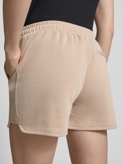 Frauenmodel trägt Shorts mit elastischem Bund Modell 'KATE PIQUE' von ICHI aus Baumwoll-Mix in Beige, Regular-Fit, Ganzkörperansicht Rückansicht.