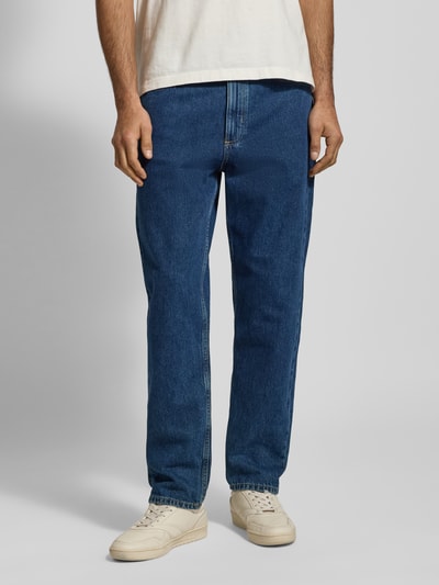 Männermodel trägt Tapered-Fit Jeans aus reiner Baumwolle Modell 'RUNNA' von Marc O'Polo Denim in klassischer Denim-Optik, Ganzkörperansicht von vorne