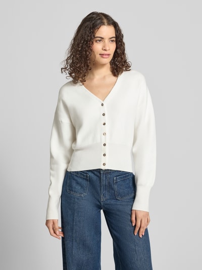 Modelka nosi kardigan z mieszanki bawełny i wiskozy, krój regular fit, model 'Compact' od Topshop, imitacja dzianiny, dekolt w serek, widok całej sylwetki z przodu.