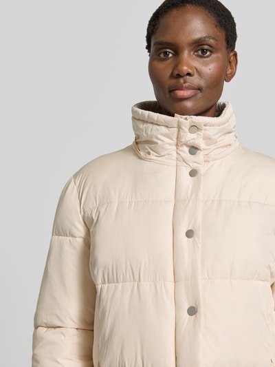 Frauenmodel trägt Steppmantel mit abnehmbarer Kapuze von White Label in Beige mit Druckknöpfen, glatte Oberfläche, Nahaufnahme Oberkörper. Gerader Schnitt, abnehmbare Kapuze mit Tunnelzug, Reiß- und Druckknopfverschluss, seitliche Reißverschlusstaschen, Rückenlänge 88 cm, Schulterbreite 42 cm, Brustweite 56 cm, Ärmellänge 65 cm.