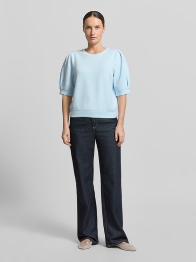 Frauenmodel trägt Regular Fit Sweatshirt aus Scuba von s.Oliver RED LABEL in Hellblau, glatte Textur, unifarben, Ganzkörperansicht von vorne.