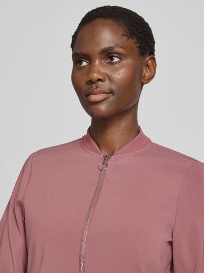 Kobiece model prezentuje Regular Fit Blouson mit Allover-Muster model 'COCO' od VERO MODA w kolorze różowym, zbliżenie na górną część ciała