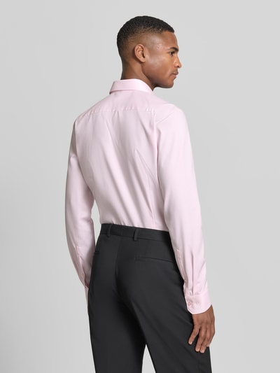 Männermodel trägt Slim Fit Businesshemd mit Kentkragen von OLYMP No. Six in Hellrosa, Baumwoll-Mix, glatte Textur, Ganzkörperansicht Rückansicht.