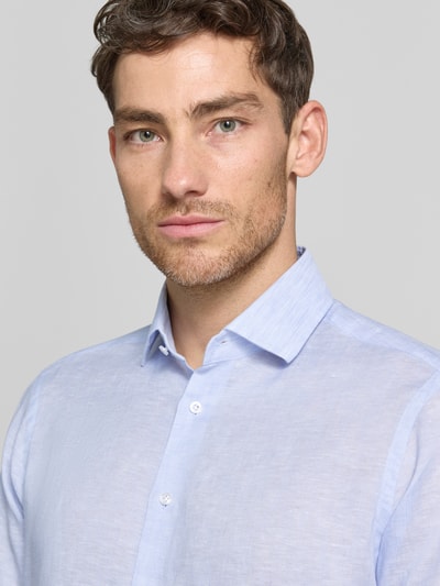 Männermodel trägt Regular Fit Leinenhemd mit Kentkragen von Christian Berg Men, hellblau, feine Leinenstruktur, Nahaufnahme Oberkörper.