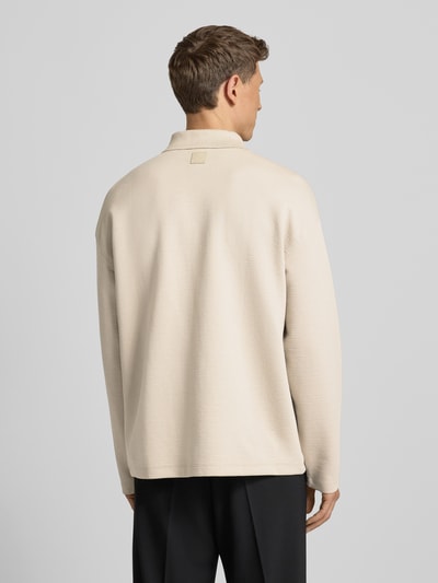 Männermodel trägt Sweatshirt mit Polokragen und Reißverschluss von CK Calvin Klein, Material-Mix mit Modal-Anteil, Relaxed-Fit, Strukturmuster in Beige, Modell CRINKLE CREPE SPACER, Rückenlänge 72 cm bei Größe M, Ganzkörperansicht Rückansicht.